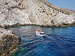 A small ship is sailing around Folegandros, Cyclades, Greece
